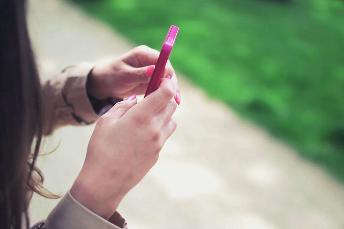 Femme rédigeant une bio sugar baby sur son téléphone avec attention